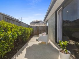 An outdoor area with a chair and umbrella at Papamoa