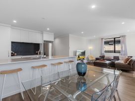 A kitchen and living room featuring a bar and dining table at Papamoa