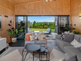 A living room with a sliding door view to an outdoor area at Whitianga
