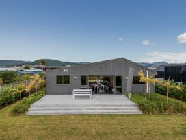 A house with a deck and outdoor furniture at Whitianga