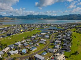 An aerial view of a residential area with houses and a river at Matarangi in Matarangi