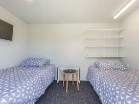 A bedroom with two beds and a television at Casa Verde - Mapua Holiday Home in Mapua