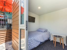 A bedroom with a bed and television at Casa Verde - Mapua Holiday Home, Mapua