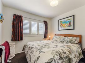 A bedroom with a bed and decorative wall art at Casa Verde - Mapua Holiday Home, Mapua