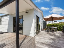 An outdoor deck with a table and umbrella at Casa Verde - Mapua Holiday Home in Mapua