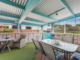 An outdoor patio with a dining table and chairs at Casa Verde - Mapua Holiday Home in Mapua
