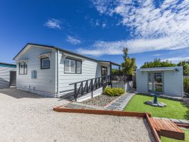 A house with a deck and garden at Casa Verde - Mapua Holiday Home in Mapua