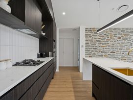 A kitchen with cabinets and a gas stove at Cromwell Holiday Home in Cromwell