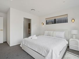 A bedroom with a bed and shelf at Cromwell Holiday Home in Cromwell