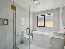 A bathroom with shower, bathtub, toilet and washbasin at Cromwell Holiday Home in Cromwell