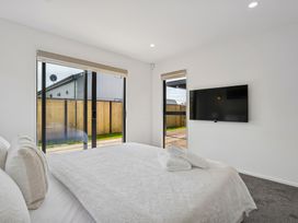 A bedroom with a bed and television at Cromwell Holiday Home in Cromwell