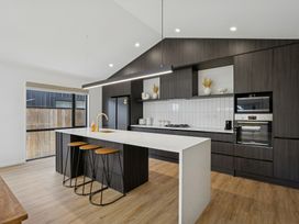 A kitchen with a kitchen island and bar stools at Cromwell Holiday Home in Cromwell