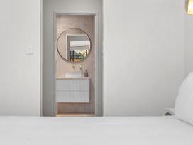 A bedroom with a view of a bathroom through a doorway at Sunrise on Vintage - Cromwell