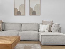 A sectional sofa with cushions and a coffee table at Sunrise on Vintage - Cromwell Holiday Home in Cromwell