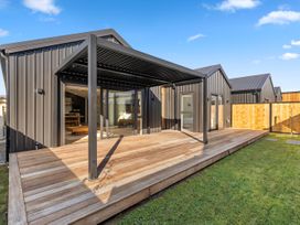 A patio area with a pergola and wooden decking at Sunrise on Vintage - Cromwell