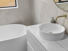 A bathroom with a bathtub and sink at Sunrise on Vintage - Cromwell Holiday Home in Cromwell