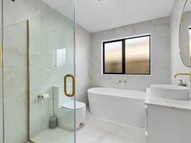 A bathroom with a shower, toilet, bathtub, and sink at Sunrise on Vintage - Cromwell Holiday Home, Cromwell