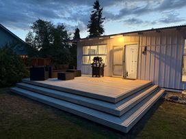 A deck with outdoor furniture and a grill at Clyde Holiday Home in Clyde