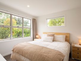 A bedroom with a bed and windows at Clyde Holiday Home in Clyde