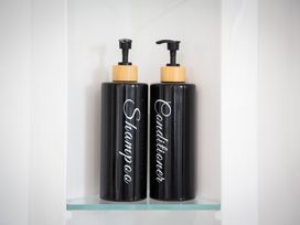 A shelf with shampoo and conditioner bottles at Clyde Holiday Home in Clyde