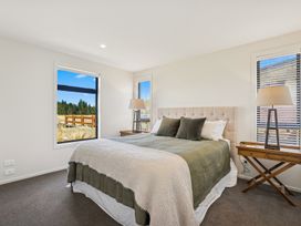 A bedroom with a bed and bedside table at Dancing Tussock Escape - Cromwell