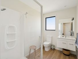 A bathroom with a shower, toilet and sink at Dancing Tussock Escape - Cromwell
