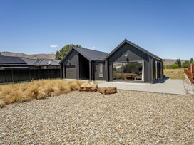 A house with a garage and landscaping at Dancing Tussock Escape - Cromwell Holiday Home, Cromwell