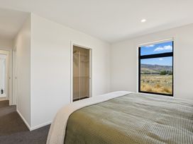 A bedroom with a bed and a window at Dancing Tussock Escape - Cromwell Holiday Home, Cromwell