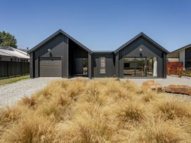 A house with a garage and outdoor area at Dancing Tussock Escape - Cromwell Holiday Home