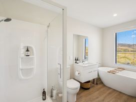 A bathroom with a shower, bathtub, and sink at Dancing Tussock Escape - Cromwell Holiday Home, Cromwell