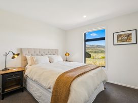 A bedroom with a bed and lamp at Dancing Tussock Escape - Cromwell Holiday Home in Cromwell
