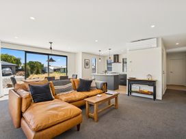 A living room with a sofa and dining table at Dancing Tussock Escape - Cromwell Holiday Home, Cromwell