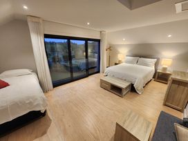 A bedroom with two beds and large windows at Studio - Point Wells Holiday Home, Point Wells