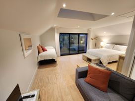 A bedroom with two beds and a sofa at Studio - Point Wells Holiday Home in Point Wells