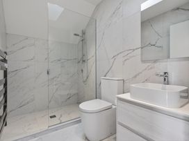 A bathroom with a shower, toilet, and sink at The Coastal Studio - Point Wells Holiday Home Point Wells