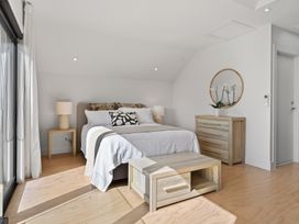 A bedroom with a bed, nightstand, and dresser at The Coastal Studio - Point Wells Holiday Home Point Wells