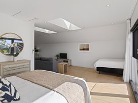 A bedroom with a bed and couch at The Coastal Studio - Point Wells Holiday Home Point Wells