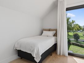 A bedroom with a bed and a window at The Coastal Studio - Point Wells Holiday Home