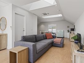 A living room with a sofa and dining area at The Coastal Studio - Point Wells Holiday Home