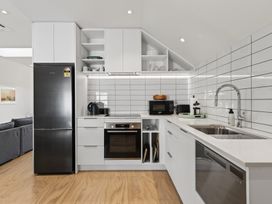 A kitchen with appliances and fixtures at The Coastal Studio - Point Wells Holiday Home