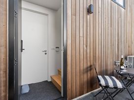 An outdoor entryway with a door, steps, and furniture at The Coastal Studio - Point Wells Holiday Home Point Wells