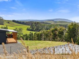 A view of a house with a deck and grass landscape at Limesprings Cottage - Milton