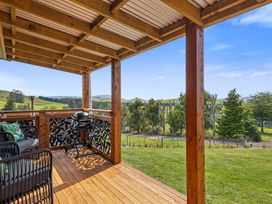 A deck with outdoor furniture and a grill at Limesprings Cottage - Milton