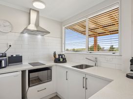 A kitchen with a sink and microwave at Limesprings Cottage - Milton