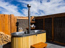 An outdoor area with a wooden hot tub at Limesprings Cottage - Milton