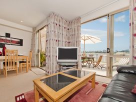A living room with a television and a coffee table at Tairua Holiday Home in Tairua