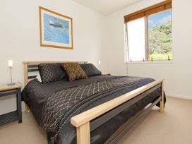 A bedroom with a bed and nightstand at Tairua Holiday Home in Tairua