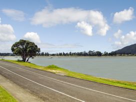 An outdoor view of a river with a road and a tree at Tairua Holiday Home in Tairua