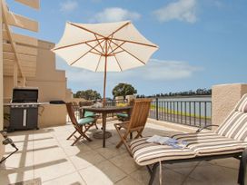 An outdoor terrace with a table and chairs at Tairua Holiday Home in Tairua