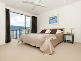 A bedroom with a bed and sliding door at Tairua Holiday Home in Tairua